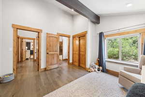 Living area featuring wood finished floors, beam ceiling, and high vaulted ceiling