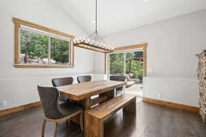 Dining area featuring healthy amount of natural light, wood finished floors, a chandelier, vaulted ceiling, and recessed lighting