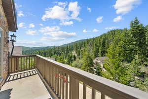 Balcony featuring a wooded view