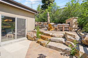 View of patio with an outdoor stone fireplace