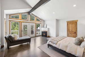 Bedroom featuring access to outside, recessed lighting, wood finished floors, and a warm lit fireplace
