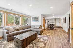 Living area featuring light wood-style flooring and recessed lighting