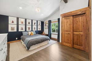Bedroom featuring vaulted ceiling, wood finished floors, recessed lighting, and a chandelier