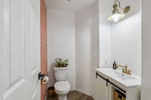 Half bath with vanity and wood finished floors