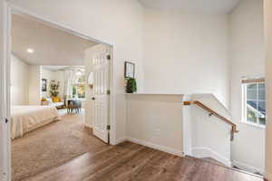 Hallway with an upstairs landing and wood finished floors