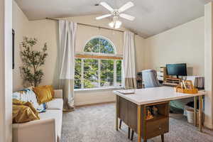 Carpeted home office featuring  vaulted ceiling