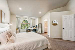 Carpeted bedroom with lofted ceiling, recessed lighting, and ensuite bath
