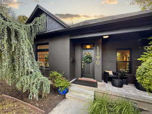 Exterior entry at dusk featuring brick siding and covered porch