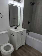 Bathroom featuring wood finished floors, vanity, and tub / shower combination