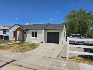 Single story home featuring an attached garage, roof with shingles, driveway, and crawl space