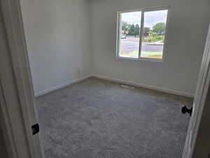 Carpeted empty room featuring baseboards