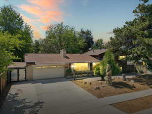View of front of property with a garage, driveway, and a chimney