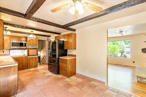 Kitchen with stainless steel microwave, smart refrigerator, wall oven, beam ceiling, and brown cabinets