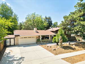 View of front of property with a garage, driveway, and a chimney