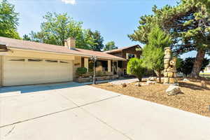 Tri-level home featuring driveway, an attached garage, and a chimney