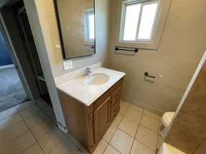 Bathroom with vanity, tile patterned floors, and a textured wall