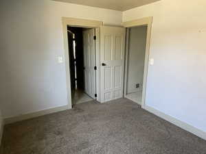 Unfurnished bedroom featuring carpet floors and baseboards