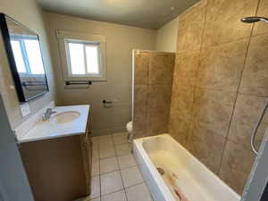 Bathroom featuring tile patterned flooring, vanity, and bathtub / shower combination