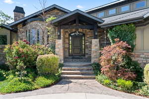 Property entrance with a chimney and stone siding