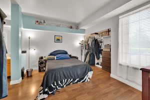 Bedroom with wood finished floors,  window, and a closet