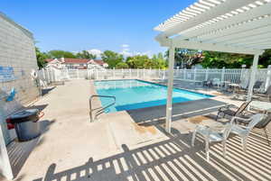 Community pool with a pergola and a patio area