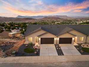 Ranch-style home with a garage, stucco siding, driveway, and a mountain view