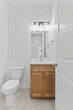 Half bath with vanity and tile patterned flooring