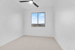Spare room with light colored carpet and ceiling fan