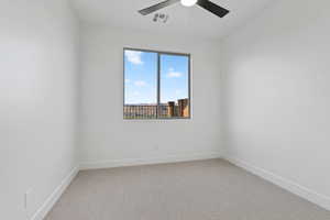 Spare room featuring a ceiling fan and carpet flooring