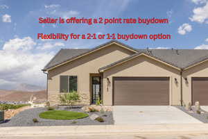 View of front of property with a garage, stucco siding, concrete driveway, stone siding, and a mountain view