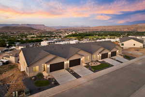 View of front facade with a garage, stucco siding, concrete driveway, a mountain view, and stone siding