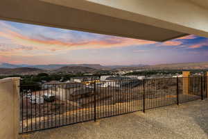 Patio terrace at dusk with a balcony and a mountain view