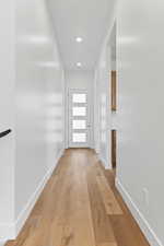Hallway featuring light wood-type flooring and recessed lighting