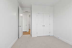 Unfurnished bedroom with carpet and a closet