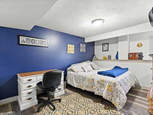 Bedroom featuring a textured ceiling and wood finished floors