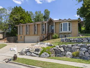 View of front of home with driveway, an attached garage, and brick siding