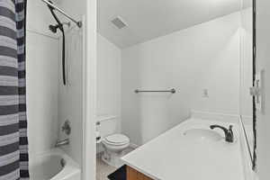 Bathroom featuring vanity, tile patterned floors, shower / tub combo with curtain, and a textured ceiling