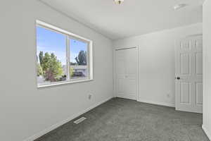 Unfurnished bedroom featuring carpet flooring and a closet