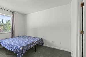 Carpeted bedroom featuring baseboards