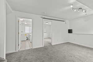 Empty room with light colored carpet and light tile patterned floors