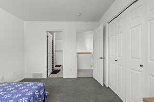 Carpeted bedroom featuring a closet and tile patterned floors