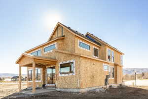 Rear view of house with a mountain view and a patio area