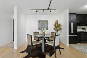 Dining room with light wood finished floors and track lighting