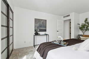 Bedroom featuring light carpet and baseboards
