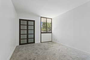 Carpeted spare room with baseboards
