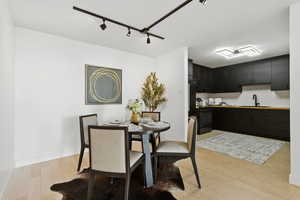 Dining space featuring light wood-style flooring and track lighting