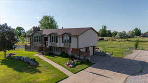 View of front of house featuring concrete driveway, a chimney, a garage, and brick siding