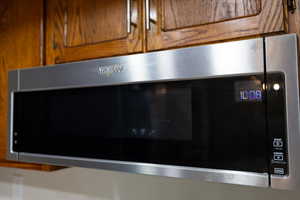 Detailed view of stainless steel microwave and brown cabinetry