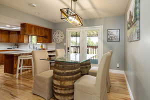 Dining room featuring light wood-type flooring, healthy amount of natural light, french doors, and recessed lighting