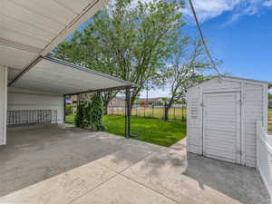 View of patio featuring a storage unit